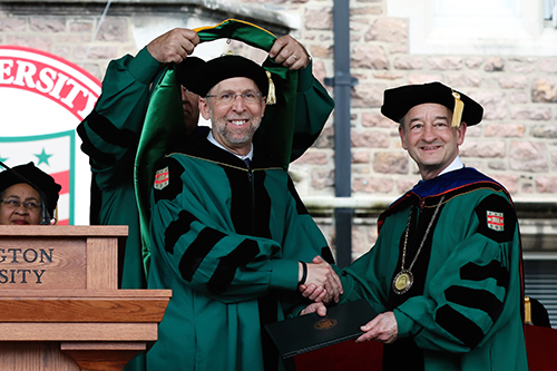 NHGRI director, Eric D. Green, M.D., Ph.D., receives an honorary degree from Washington University in St. Louis chancellor Mark S. Wrighton, Ph.D. Image credit: Joe Angeles, Washington University.