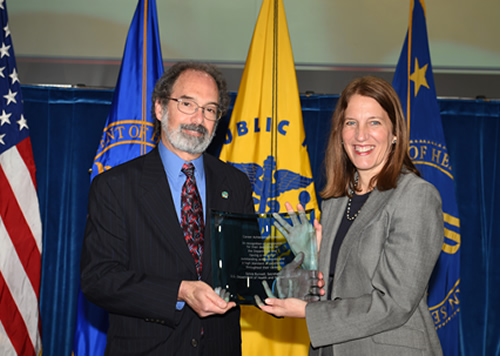 Jeffery Schloss and receives the HHS Career Achievement Award from Secretary Sylvia Burwell