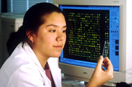 Researcher in front of a computer displaying data