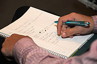Hands with pen, notebook and notes