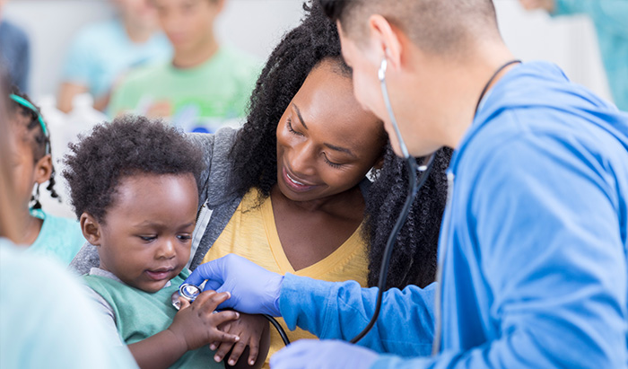 Nurse checking heartbeat of a young boy