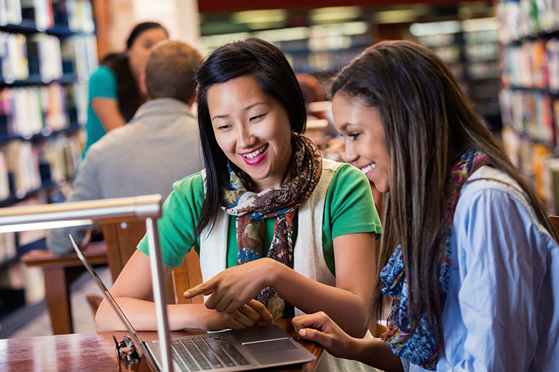 Asian and African American female students in the library