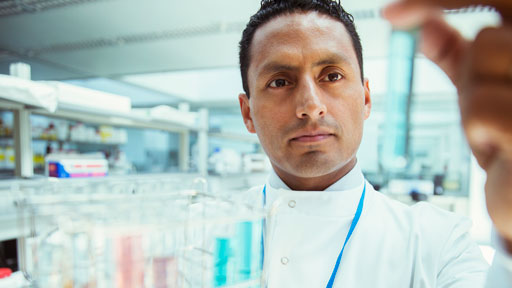 Scientist looking at vial