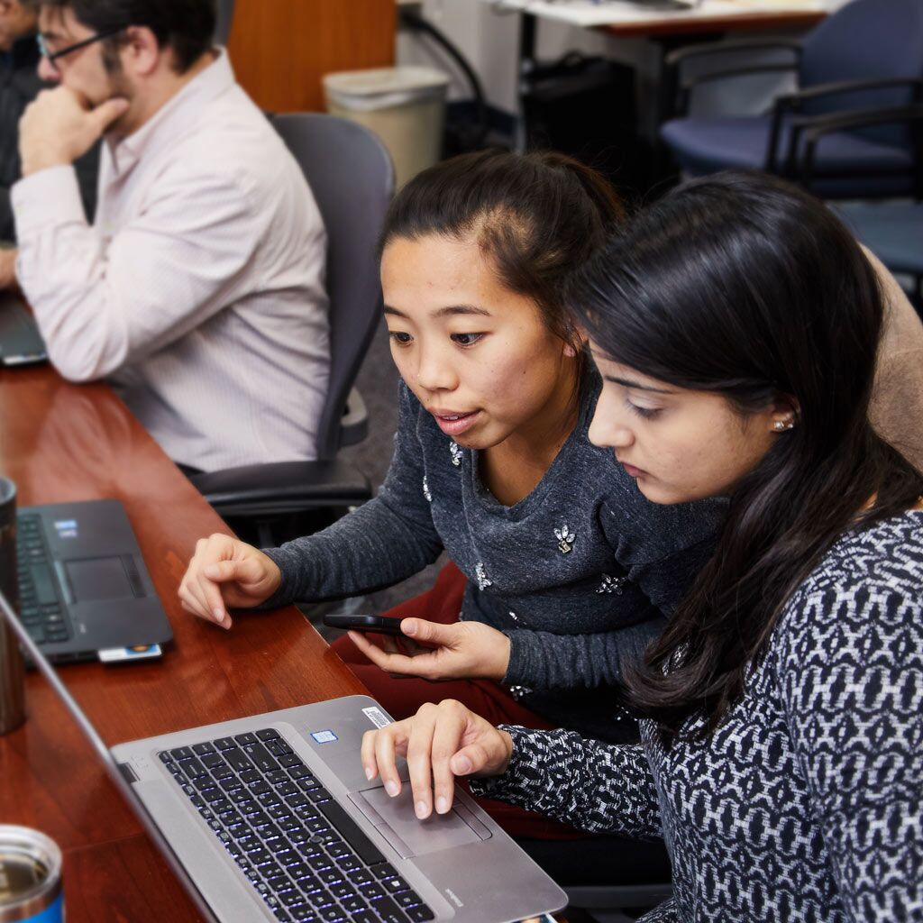 Two women use computer