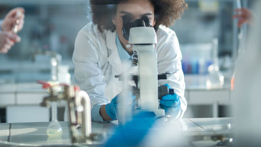 Woman looks at microscope