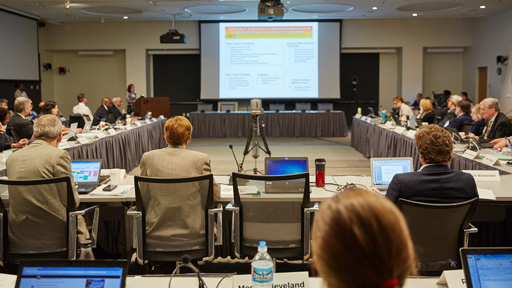 People around the table looking at a large screen