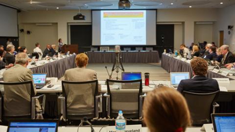 People around the table looking at a large screen