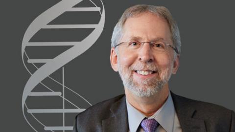 portrait of Dr. Eric Green in front of patterned background